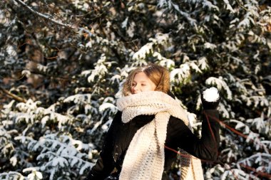 Young woman throwing snowball