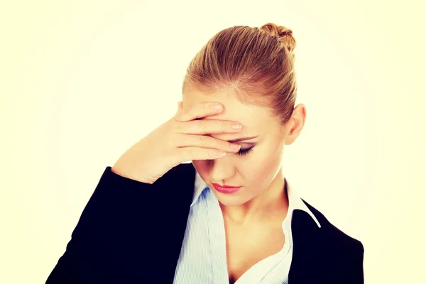 Zakelijke vrouw met een enorme hoofdpijn houden hoofd — Stockfoto