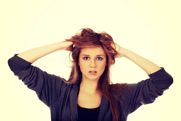 Giovane donna sorpresa che si tiene per mano dentro i capelli — Foto Stock