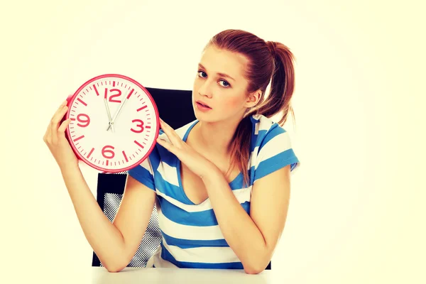 Teenage woman looking at clock — Stock Photo, Image