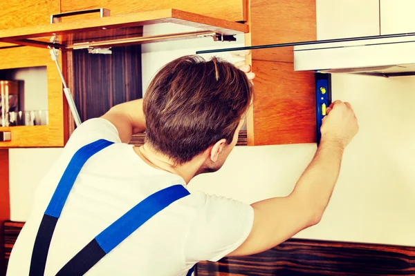 Young handyman with spirit level — Stock Photo, Image