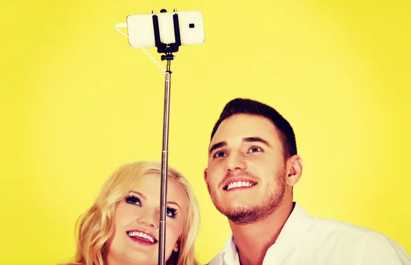 Pareja feliz tomando foto selfie con palo selfie —  Fotos de Stock