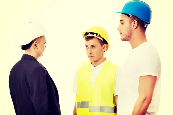 Engenheira mulher conversando com dois construtores — Fotografia de Stock