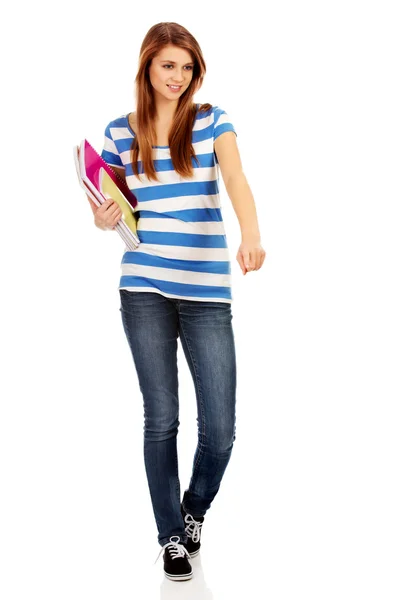 Dospívající šťastná žena drží učebnice a ukazoval na něco — Stock fotografie