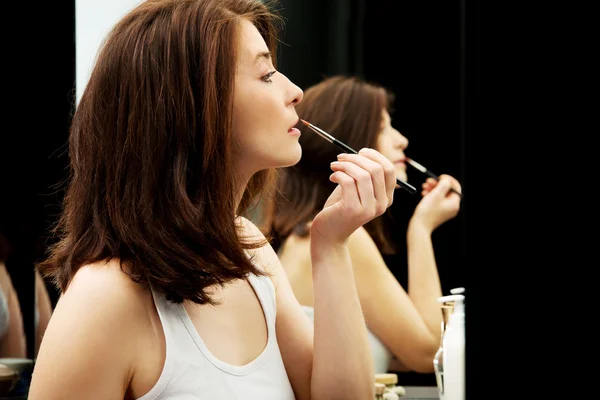 Frau trägt Lippenstift auf. — Stockfoto