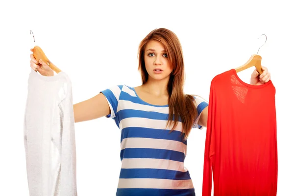 Tiener vrouw met twee shirts denken wat te kleden — Stockfoto