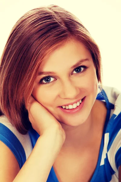 Smiling teenage woman sitting on a floor Stock Photo