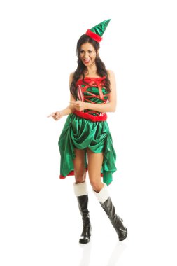 Sağa işaret eden elf elbise giyen tam uzunlukta kadın