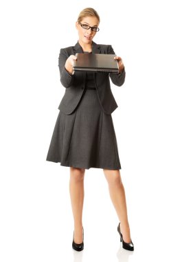 Ayakta ve bir dizüstü bilgisayar tutan bir işkadını