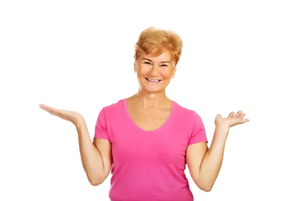 An old smiling woman presenting something — Stock Photo, Image