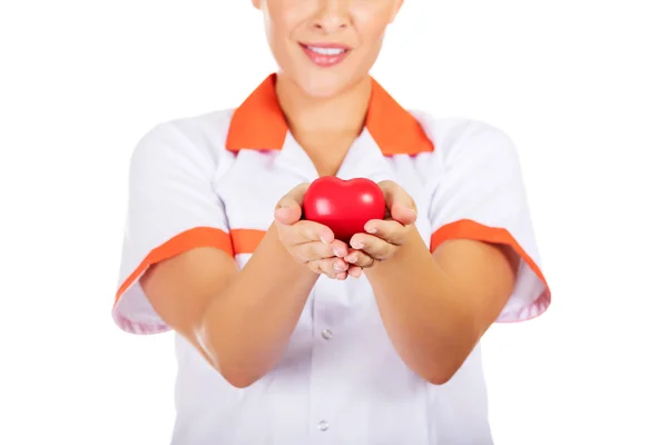Young female doctor or nurse holding toy heart — Stock Photo, Image
