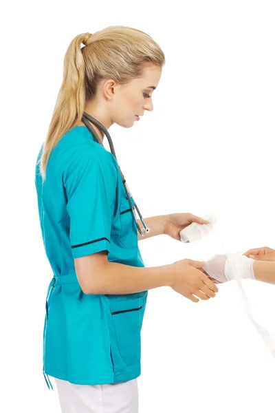 Młoda kobieta lekarz bandażowanie dłoni kobieta — Zdjęcie stockowe