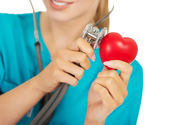 Medico femminile ascolta il cuore attraverso uno stetoscopio — Foto Stock