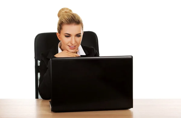 Joven mujer de negocios sonrisa detrás del escritorio, utilizando el ordenador portátil —  Fotos de Stock