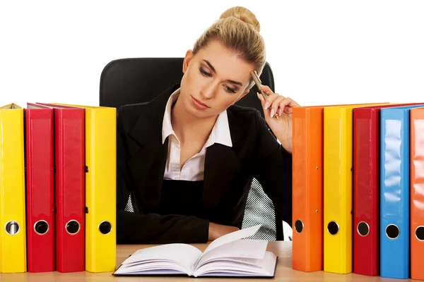 Exhausted businesswoman with binders behind the desk — Stock Photo, Image
