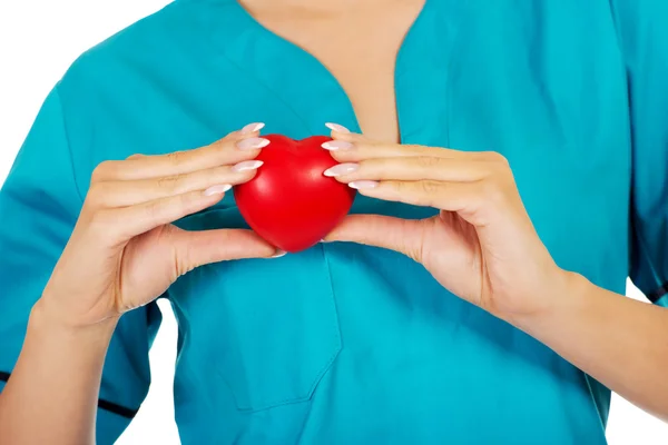 Nurse or female doctor holding red heart. — Stock Photo, Image