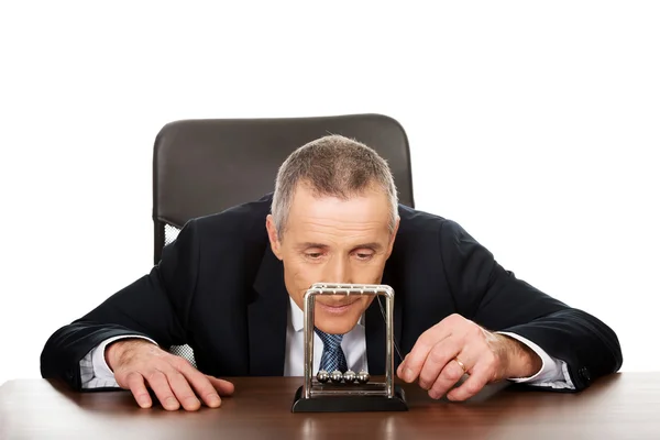 Empresário no escritório brincando com bolas de newton — Fotografia de Stock