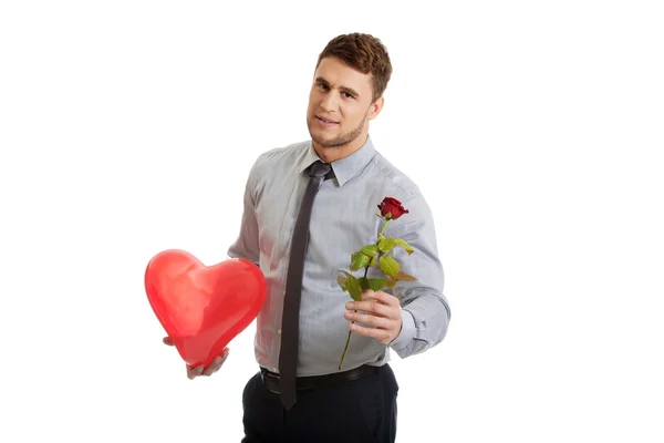 Junger Mann mit roter Rose und Herzballon. — Stockfoto