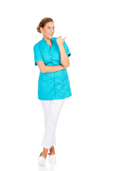 Giovane medico femminile mostrando qualcosa da pollice — Foto Stock