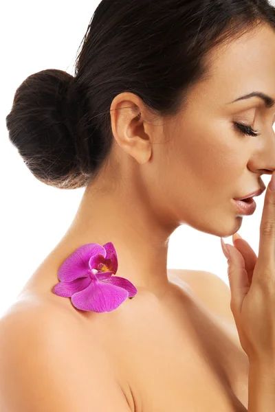 Donna con petalo di orchidea viola sulla spalla — Foto Stock