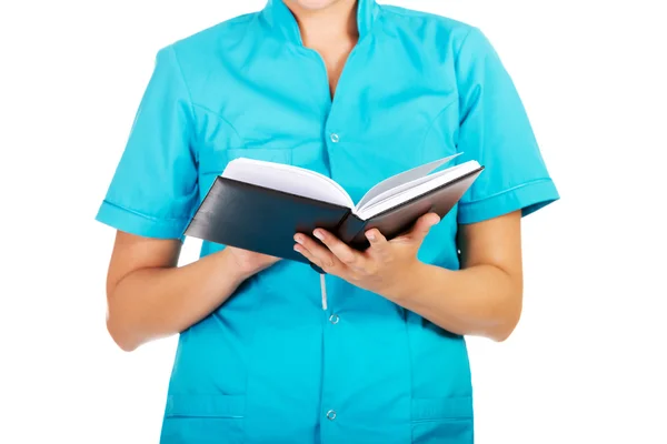 Νεαρή γυναίκα γιατρός ή νοσοκόμα κρατώντας μαύρες σημειώσεις — Φωτογραφία Αρχείου