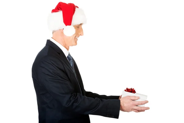 Visão lateral retrato de Papai Noel com um presente — Fotografia de Stock