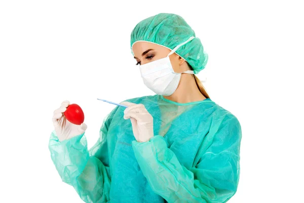 Unga kvinnliga kardiolog surgeron hålla hjärta och skalpell — Stockfoto