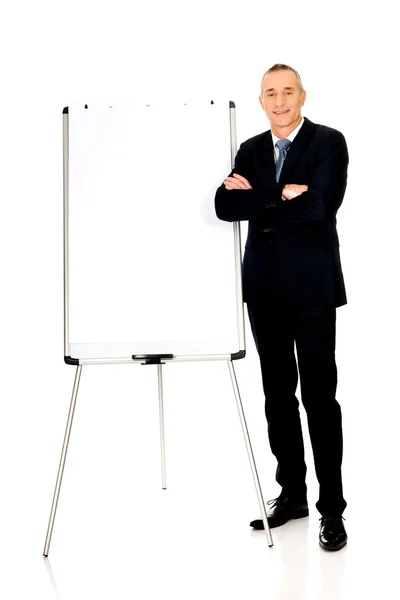 Uomo esecutivo in piedi vicino a flip chart — Foto Stock