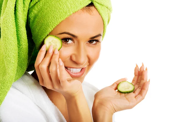 Mujer en albornoz aplicando pepino en los ojos — Foto de Stock