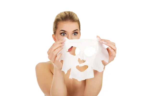 Jeune femme surprise avec masque facial — Photo