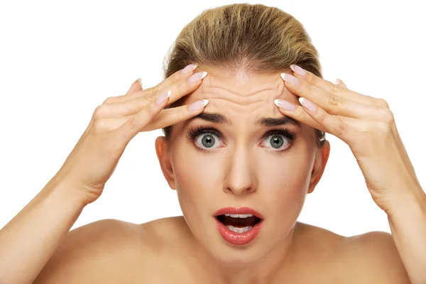 A young woman checking wrinkles on her forehead — Stock Photo, Image