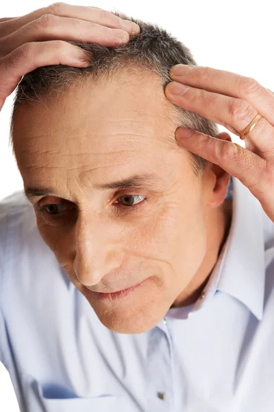 Uomo esaminando i suoi capelli — Foto Stock