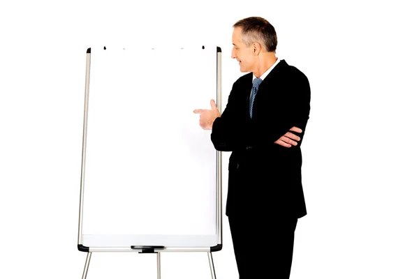 Mężczyzna naczelny wskazując na tablicę typu flip chart — Zdjęcie stockowe