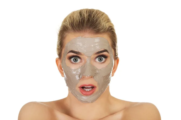 Young surprised woman with facial mask — Stock Photo, Image