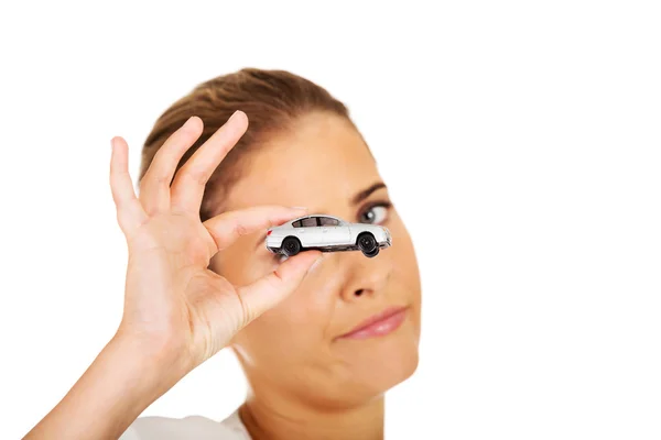 Young businesswoman holding a toy car — Stock Photo, Image