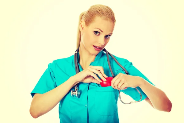 Médico sonriente con estetoscopio que sostiene el modelo de corazón —  Fotos de Stock