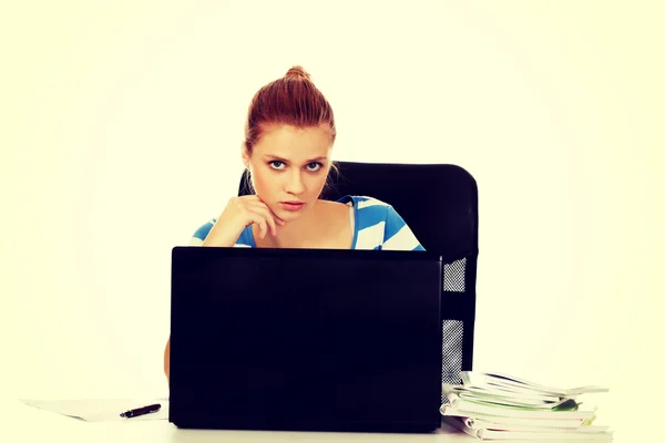 Teenage vrouw met laptop zitten achter de balie — Stockfoto