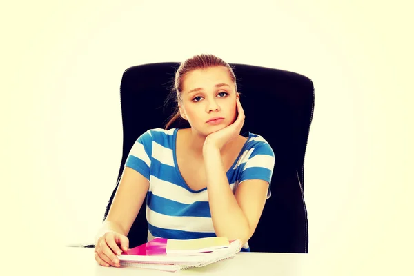 Adolescente fatiguée assise derrière le bureau — Photo