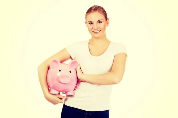 Glad ung kvinna anläggning piggybank — Stockfoto