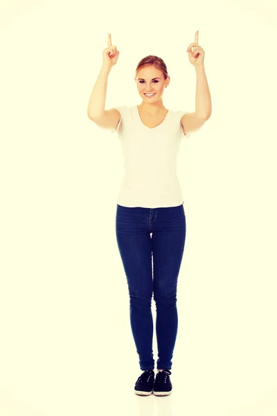 Heureuse jeune femme pointant vers le haut avec les deux mains — Photo