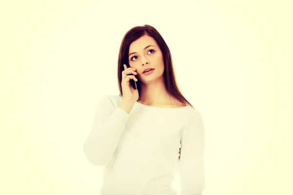 Mulher adolescente pensativo falando através de um telefone móvel — Fotografia de Stock
