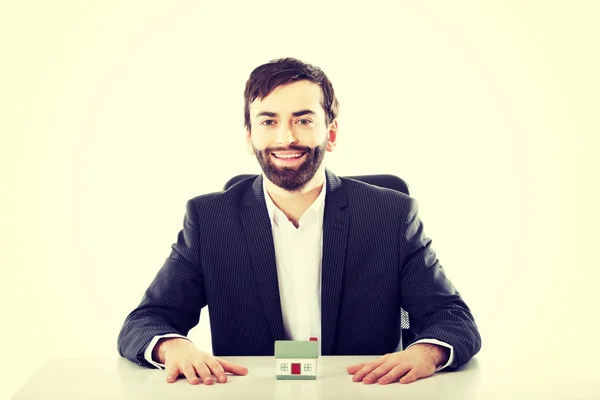 Businessman with a mini house in the office. — Stock Photo, Image