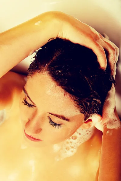 Jovem mulher relaxante lavar o cabelo no banho — Fotografia de Stock