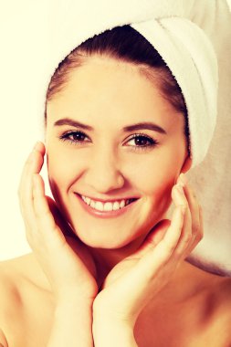 Genç mutlu kadın yüzüne dokunuyor.
