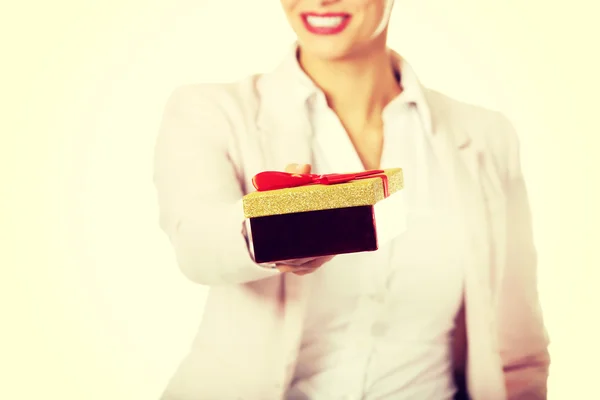 Smiling young business woman holding present box — Stock Photo, Image