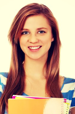 Elinde birkaç defter tutan genç bir kadın.