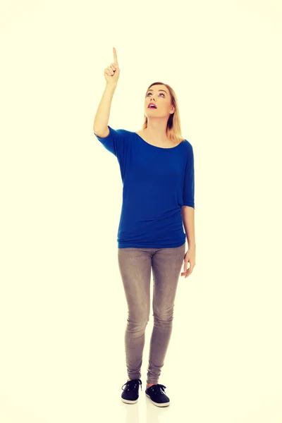 Happy young woman pointing up — Stock Photo, Image