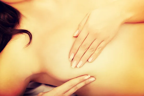 Woman examining her breast in bed. — Stock Photo, Image