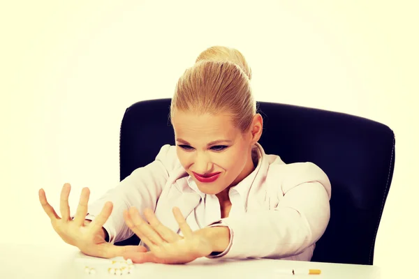 Biznes kobieta siedzi za biurkiem nie chce palić — Zdjęcie stockowe