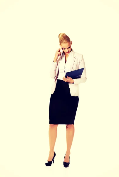 Nachdenkliche fokussierte Geschäftsfrau liest ihre Notizen — Stockfoto